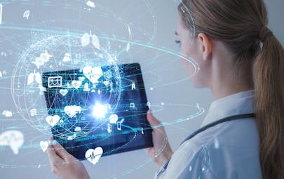 healthcare professional holding tablet with electronic futuristic symbols emitting from it healthcare professional holding tablet with electronic futuristic symbols emitting from it